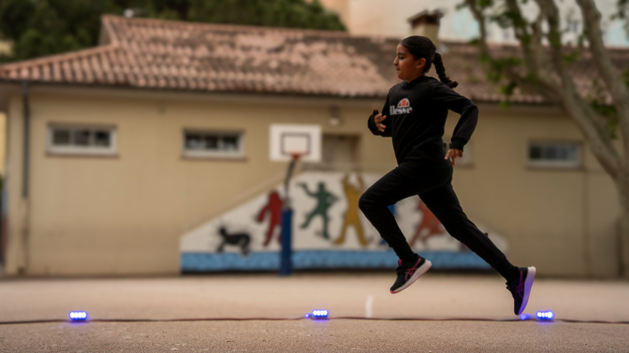 Enfant courant dans la cour d'école, illustrant l'engagement du Meeting Nikaia 2025 pour le pilier social à travers l'activité physique des jeunes le MINIKAIA.